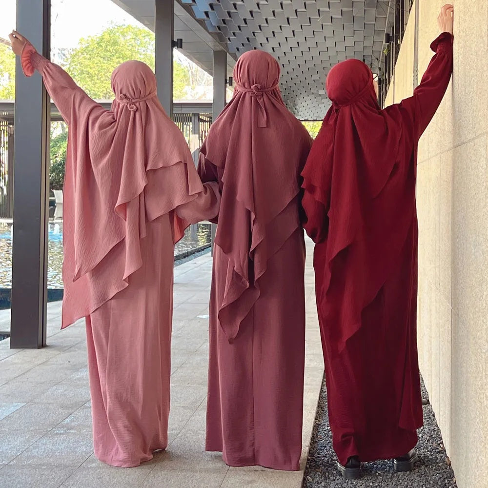 Discover the ethereal charm of our Blush Pink Crepe Crinkle Abaya with Double Layer Khimar Set, a unique blend of modesty and radiance found exclusively at Hikmah Boutique. The delicate blush pink hue embodies timeless grace, creating an ensemble that seamlessly weaves tradition and contemporary style.