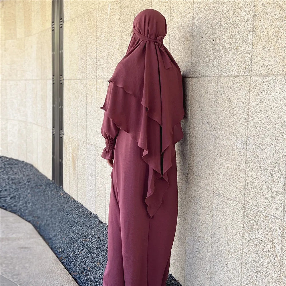 Discover the ethereal charm of our Blush Pink Crepe Crinkle Abaya with Double Layer Khimar Set, a unique blend of modesty and radiance found exclusively at Hikmah Boutique. The delicate blush pink hue embodies timeless grace, creating an ensemble that seamlessly weaves tradition and contemporary style.