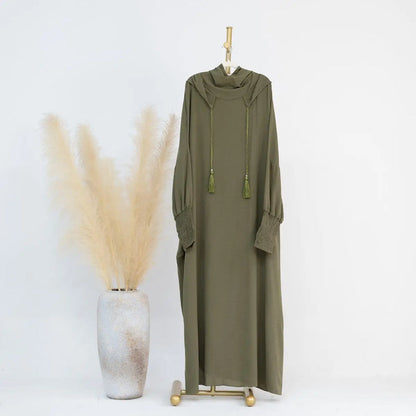 Discover the serene elegance of our Olive Green Hooded Jilbab Abaya, a manifestation of modesty and sophistication exclusively available at Hikmah Boutique. Crafted with meticulous attention to detail, this refined garment is designed to elevate your modest wardrobe with grace and poise.