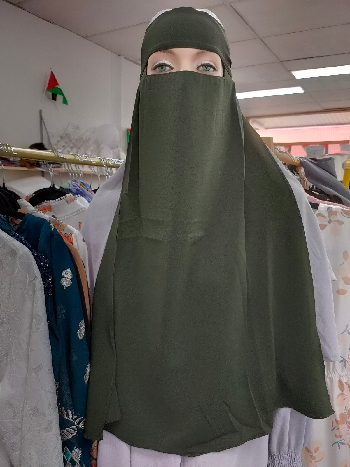 Embrace the timeless elegance of the Hikmah Boutique Single Layer Niqab in Olive Green. Crafted with care from premium materials, this niqab combines coverage and comfort in a design that exudes sophistication in Modest Clothing.