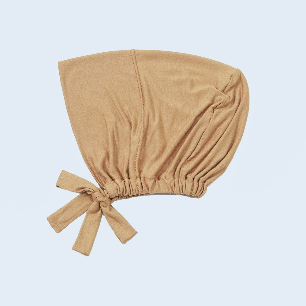 Discover Tan Peach Bamboo Closed Hijab Cap at Hikmah Boutique. Moisture-wicking, soft bamboo with an adjustable tie-back. Pairs well with Matching Undercaps. Shop now!