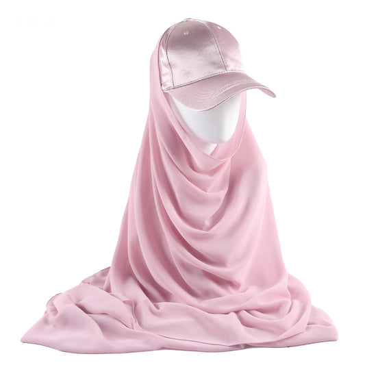 Indulge in the enchanting allure of the Blossom Pink Satin Baseball Cap with Chiffon Hijab, a delightful creation from Hikmah Boutique. This unique accessory seamlessly fuses the casual charm of a classic baseball cap with the silky softness of satin and the delicate flow of chiffon hijab. 