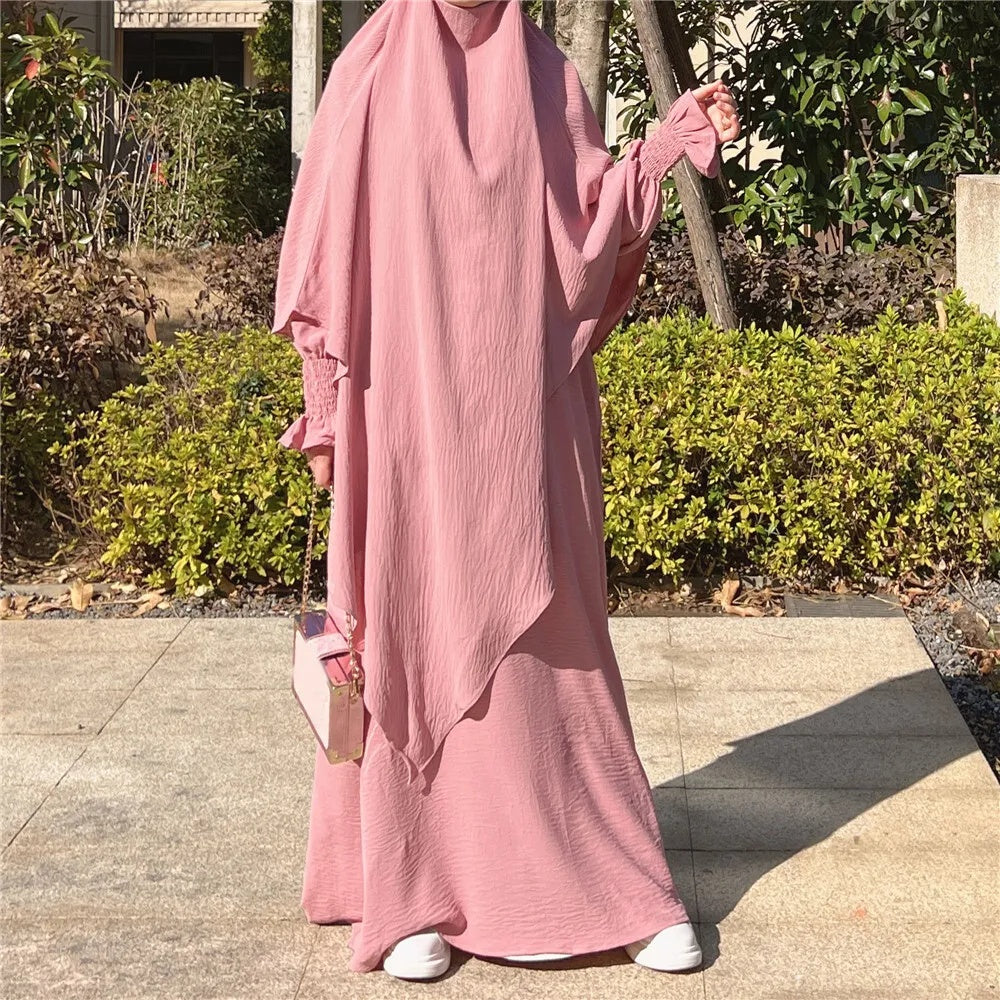 Elevate your style with the charm of our Blossom Pink Crepe Crinkle Abaya with Double Layer Khimar Set, a sublime creation exclusively available at Hikmah Boutique. The gentle blush of blossom pink transcends tradition, merging seamlessly with modest design to offer an ensemble that epitomizes grace and sophistication.