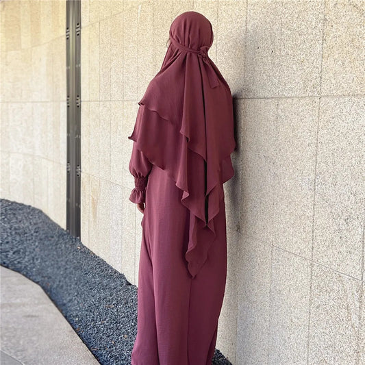 Discover the ethereal charm of our Blush Pink Crepe Crinkle Abaya with Double Layer Khimar Set, a unique blend of modesty and radiance found exclusively at Hikmah Boutique. The delicate blush pink hue embodies timeless grace, creating an ensemble that seamlessly weaves tradition and contemporary style.