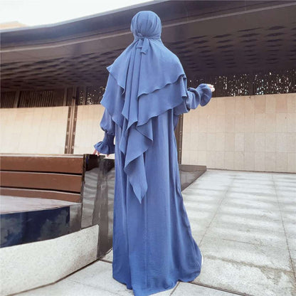 Embark on a journey of refined elegance with our Dusty Royal Blue Crepe Crinkle Abaya with Double Layer Khimar Set, an exclusive masterpiece available only at Hikmah Boutique. Immerse yourself in the regal hues of dusty royal blue, where tradition meets contemporary style in a perfect symphony of modesty and sophistication.