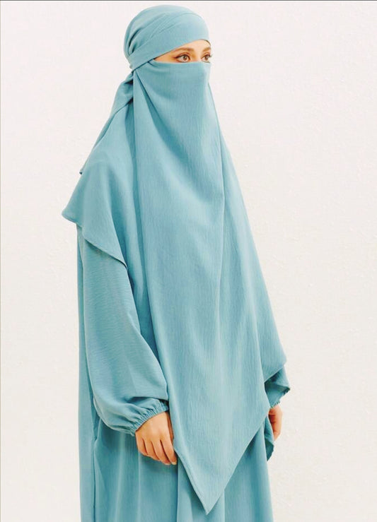 Introducing our stunning Crepe Double Layer Khimar in Aqua, available exclusively at Hikmah Boutique. Crafted with meticulous attention to detail, this khimar is meticulously designed to elevate your modest fashion game to new heights. 