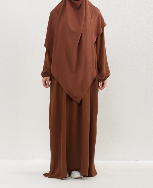 Introducing our exquisite Crepe Double Layer Khimar in Mocha, a distinctive addition to our collection at Hikmah Boutique—where modest fashion finds its essence. Crafted with meticulous care, this khimar epitomizes our dedication to enhancing your modest wardrobe with grace.