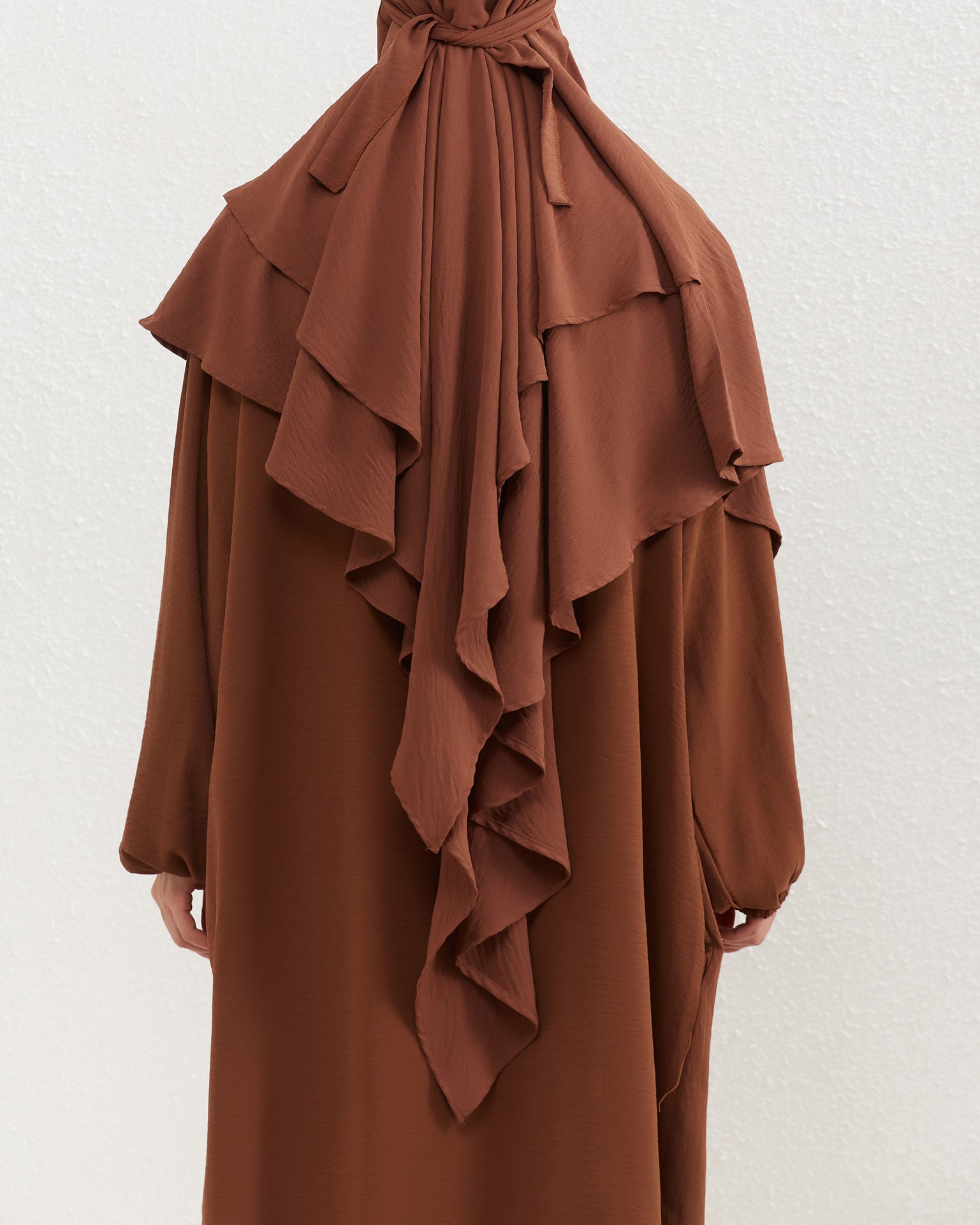 Introducing our exquisite Crepe Double Layer Khimar in Mocha, a distinctive addition to our collection at Hikmah Boutique—where modest fashion finds its essence. Crafted with meticulous care, this khimar epitomizes our dedication to enhancing your modest wardrobe with grace.