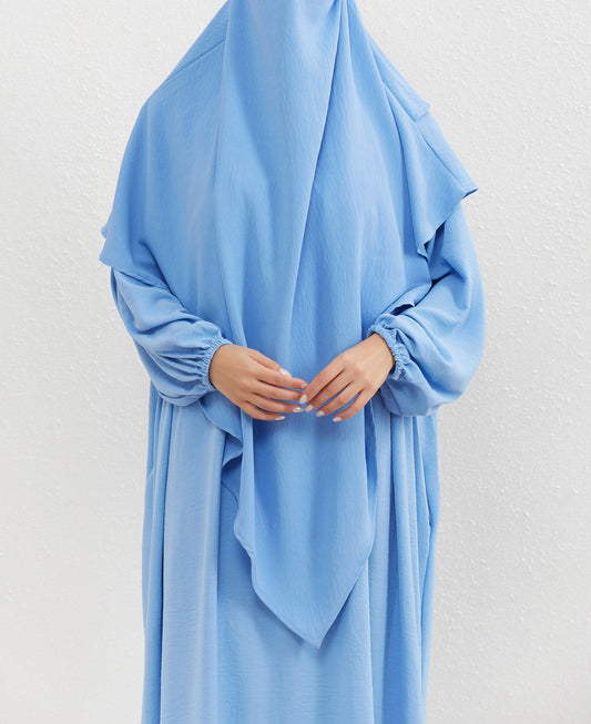 Introducing our graceful Crepe Double Layer Khimar in Sky Blue, available exclusively at Hikmah Boutique. Crafted with meticulous attention to detail, this khimar is designed to enhance your modest attire with a touch of serene elegance.
