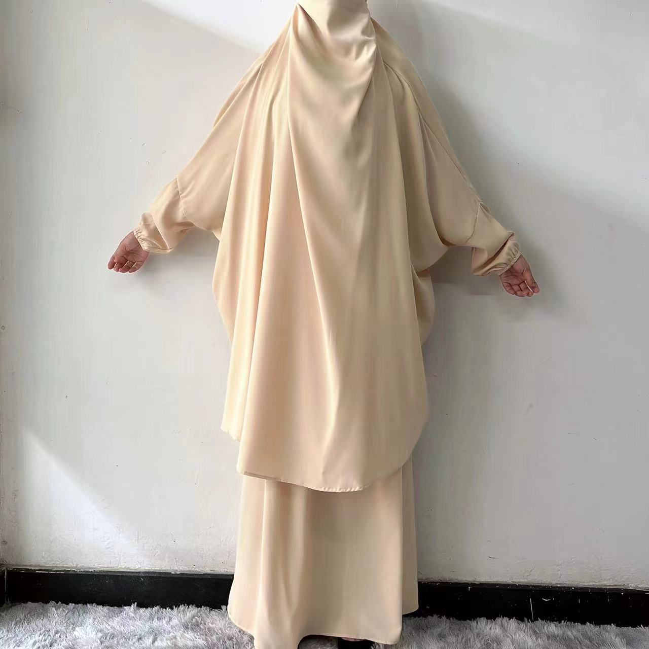 Step into serene elegance with our Cream Beige French Jilbab Prayer Set, exclusively at Hikmah Boutique. This one-size jilbab and skirt set with cuff sleeves is crafted from soft, breathable Nida fabric, providing ultimate comfort.