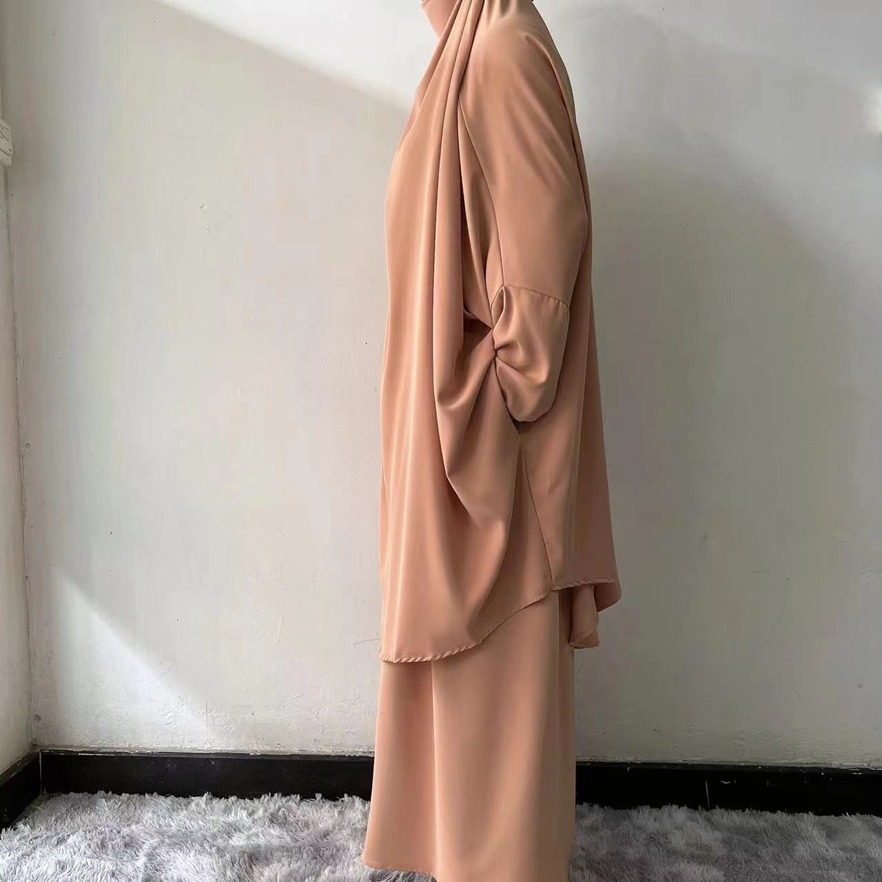 Step into refined elegance with our Teak Tan French Jilbab Prayer Set, exclusively at Hikmah Boutique. This one-size jilbab and skirt set, featuring cuff sleeves, is crafted from high-quality Nida fabric for maximum comfort and breathability.