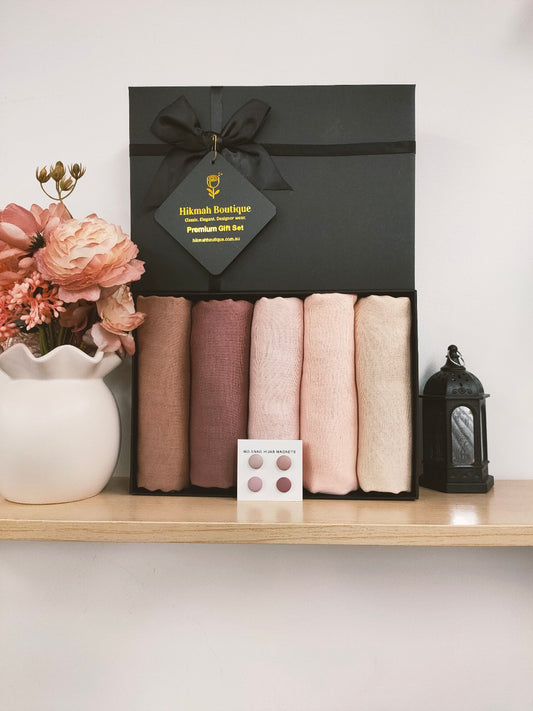 Hijab Gift Box - The Roseate Range, available at Hikmah Boutique. Elevate your hijab collection with this stunning ensemble of premium viscose hijabs to enhance your style and sophistication. Each box features five beautiful hijabs in Blossom Pink, Blush Pink, Dusty Pink, Cream Waffle, and Saddle Brown colors.