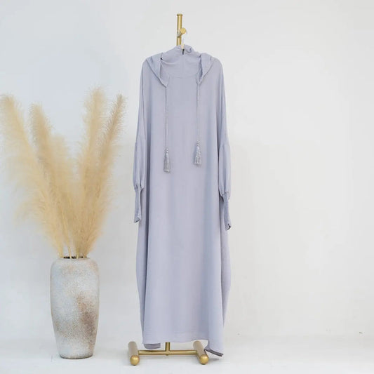 Experience timeless elegance with our Silver Grey Hooded Jilbab Abaya, a symbol of refined modesty exclusively available at Hikmah Boutique. Crafted with meticulous attention to detail, this sophisticated garment is designed to elevate your modest wardrobe with grace and sophistication.