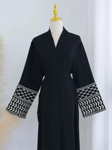 Elevate your style with the Keffiyeh Sleeve Abaya in Black. A powerful blend of tradition and modesty. Buy this symbolic abaya online at Hikmah Boutique today.