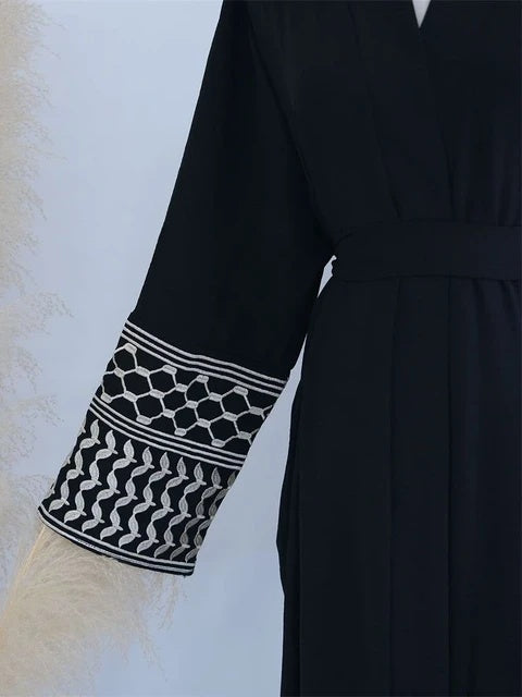 Elevate your style with the Keffiyeh Sleeve Abaya in Black. A powerful blend of tradition and modesty. Buy this symbolic abaya online at Hikmah Boutique today.