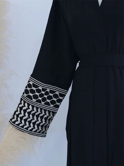 Elevate your style with the Keffiyeh Sleeve Abaya in Black. A powerful blend of tradition and modesty. Buy this symbolic abaya online at Hikmah Boutique today.