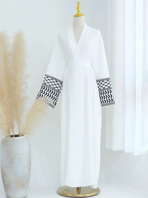 Discover the elegance of the Keffiyeh Sleeve Abaya in White. Shop this symbolic and stylish abaya online at Hikmah Boutique. Perfect for cultural pride and modest clothing.