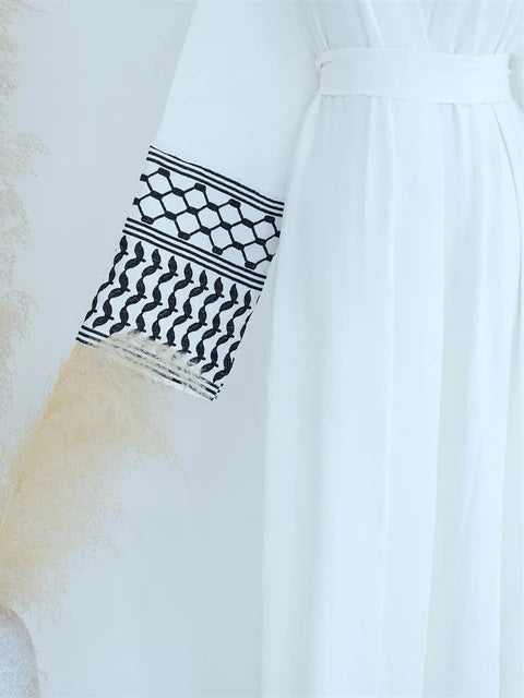 Discover the elegance of the Keffiyeh Sleeve Abaya in White. Shop this symbolic and stylish abaya online at Hikmah Boutique. Perfect for cultural pride and modest clothing.