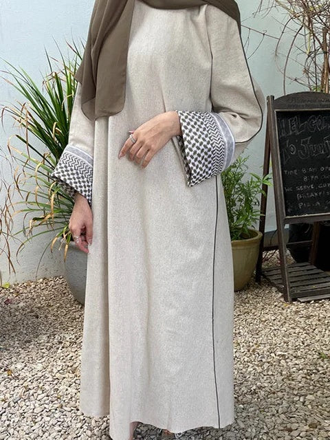 The Keffiyeh Sleeve Abaya in Light Khaki by Hikmah Boutique is more than just a modest garment; it's a symbol of solidarity with Palestine. This closed abaya features the traditional Keffiyeh pattern on the sleeves. Buy online Australia.