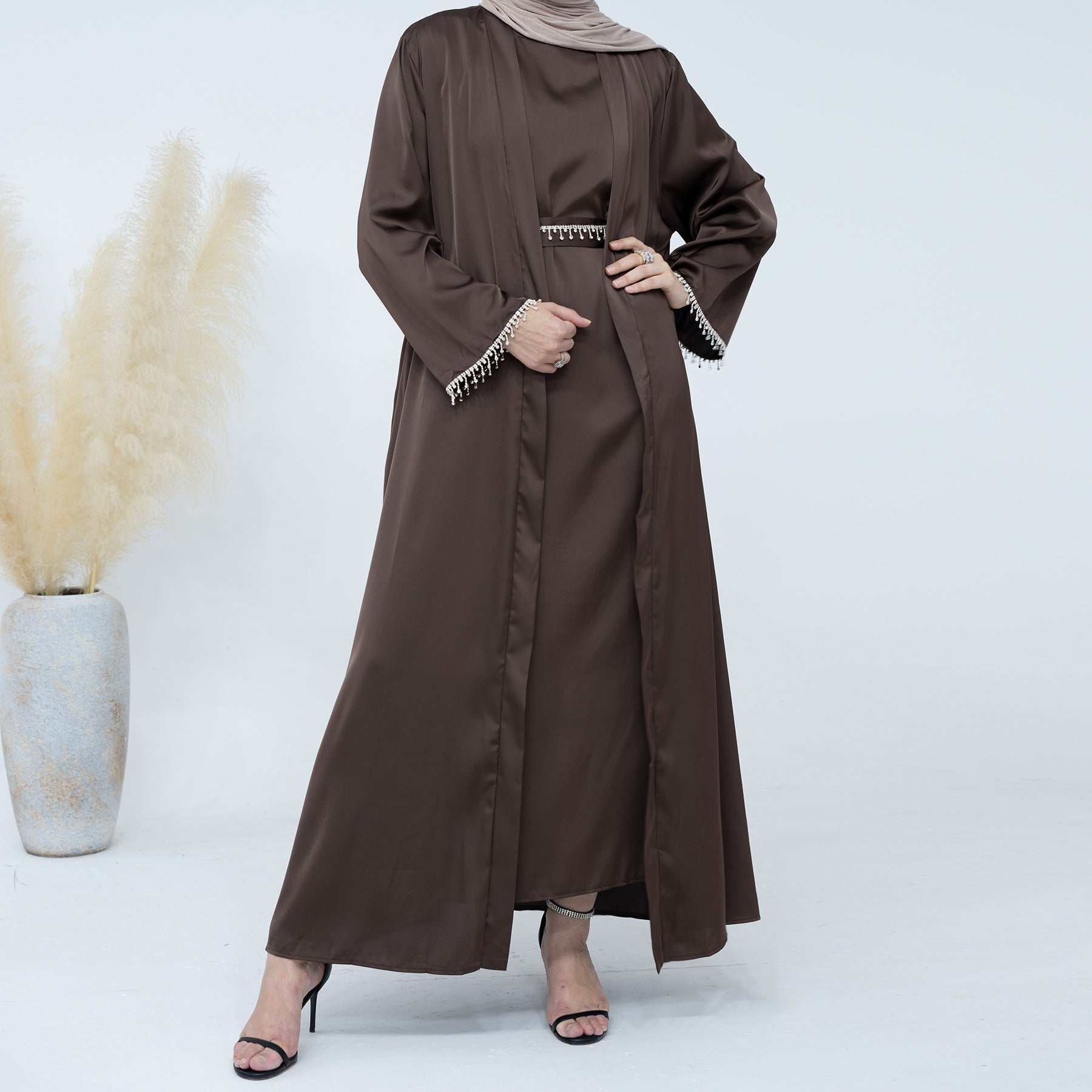 Introducing the Malika Abaya in Coffee, available at Hikmah Boutique. Crafted meticulously with luxurious Satin silk material, this exquisite ensemble promises unparalleled comfort and opulence. The Malika Abaya in Coffee is a sophisticated addition to your modest clothing wardrobe, offering timeless elegance.