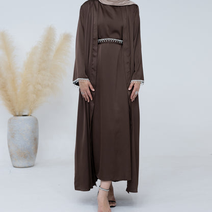 Introducing the Malika Abaya in Coffee, available at Hikmah Boutique. Crafted meticulously with luxurious Satin silk material, this exquisite ensemble promises unparalleled comfort and opulence. The Malika Abaya in Coffee is a sophisticated addition to your modest clothing wardrobe, offering timeless elegance.