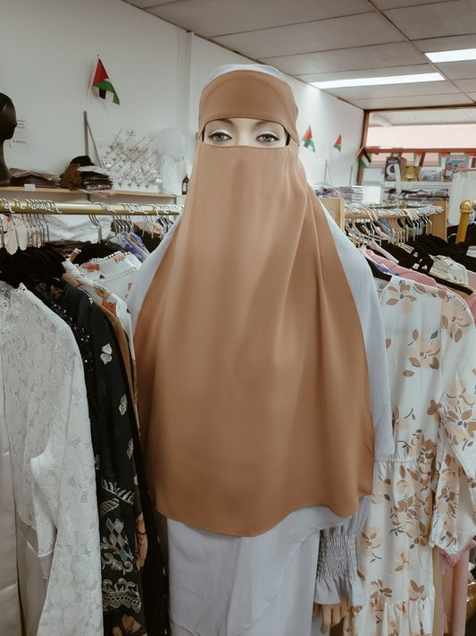 Discover the understated allure of the Hikmah Boutique Single Layer Niqab in Dusty Brown. This finely tailored niqab embodies the essence of modest clothing, offering both coverage and comfort in a design that exudes elegance. 