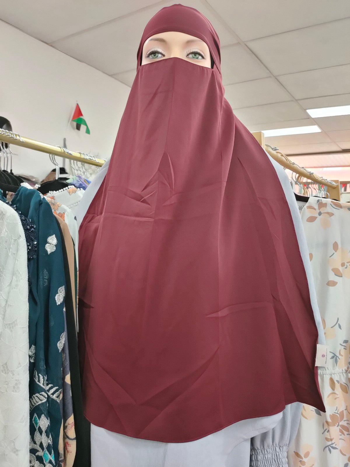 Discover the captivating allure of the Hikmah Boutique Single Layer Niqab in Maroon. This finely tailored niqab embodies the essence of modest clothing, offering both coverage and comfort in a design that exudes timeless sophistication.