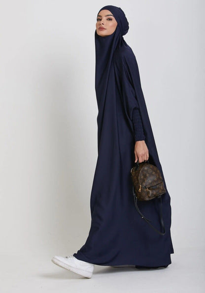 Dive into divine tranquility with our Navy One Piece Tie-Up Jilbab. This exclusive Islamic garment seamlessly blends modesty with contemporary allure, creating a captivating fusion of grace and comfort for your sacred moments of devotion.