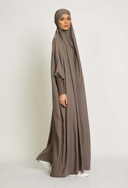 Embark on a journey of tranquil elegance with our Sandstone One Piece Tie-Up Jilbab. Tailored from premium satin material, this exclusive Islamic garment seamlessly weaves modesty with contemporary allure, creating a captivating symphony of grace and comfort for your sacred moments of devotion.