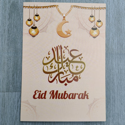 Introducing the exquisite Eid Greeting Card by Hikmah Boutique - a stunning piece of art crafted to celebrate the joy and beauty of the auspicious occasion of Eid. This card is a true masterpiece that captures the essence of the festival, making it the perfect choice to convey your heartfelt wishes to your loved ones. 