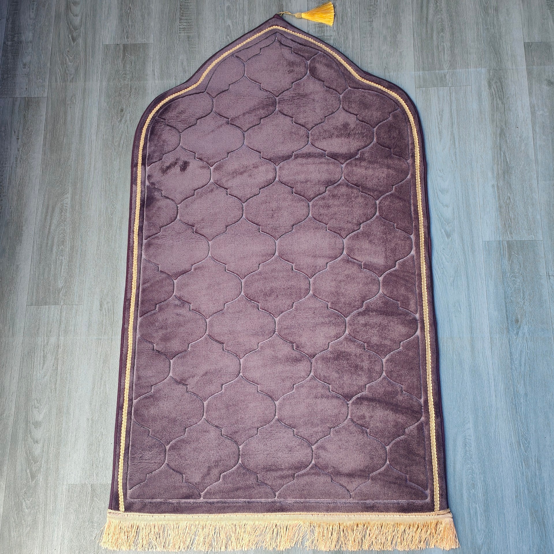 Introducing the exquisite Eggplant purple color prayer mat designed by Hikmah Boutique, a true masterpiece that embodies elegance, comfort, and spirituality. Measuring 110cm by 65cm, this prayer mat provides ample space for you to pray in peace and tranquility. This Prayer Mat is crafted with meticulous golden border.