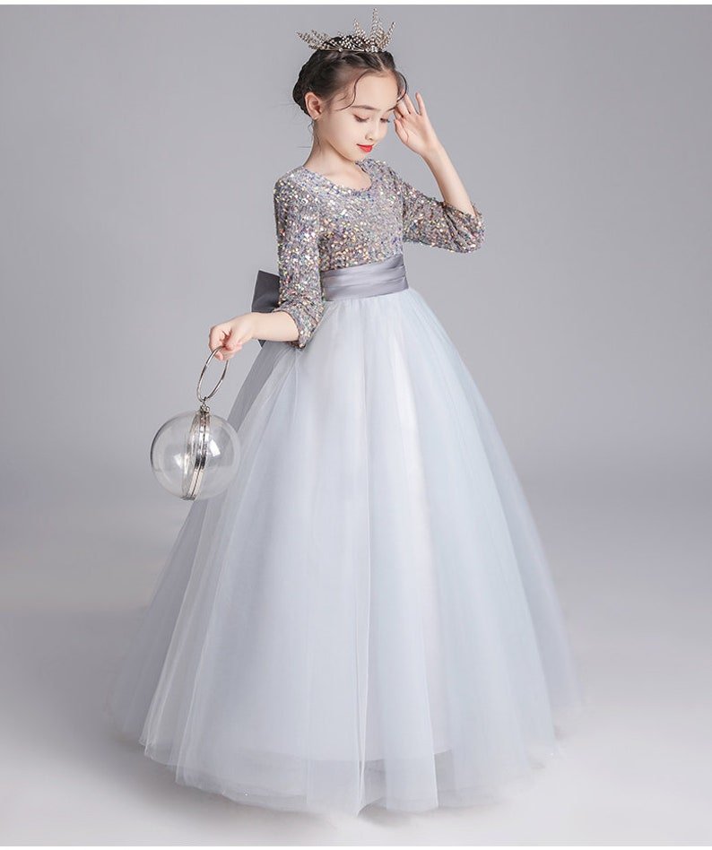 Introducing our exquisite Organza Girls Dress from Hikmah Boutique, a true embodiment of elegance and grace. This enchanting dress is designed to make your little princess feel like royalty on any special occasion. Crafted with meticulous attention to detail, this dress is perfect for weddings, parties, and formal events.